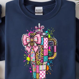 Puede incluir: Un juego de tres tazas de cerámica con un acabado mate moteado. Las tazas son de color crema, gris y negro. Cada taza tiene un diseño simple y minimalista, ideal para café o té. Las tazas están apiladas una encima de otra.