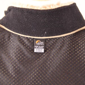 Pode incluir: Casaco de l&atilde; preto com forro de malha castanho e uma etiqueta castanha que diz "Lowe Alpine" e "Made in/Fait au Canada" e "Womens X Large".