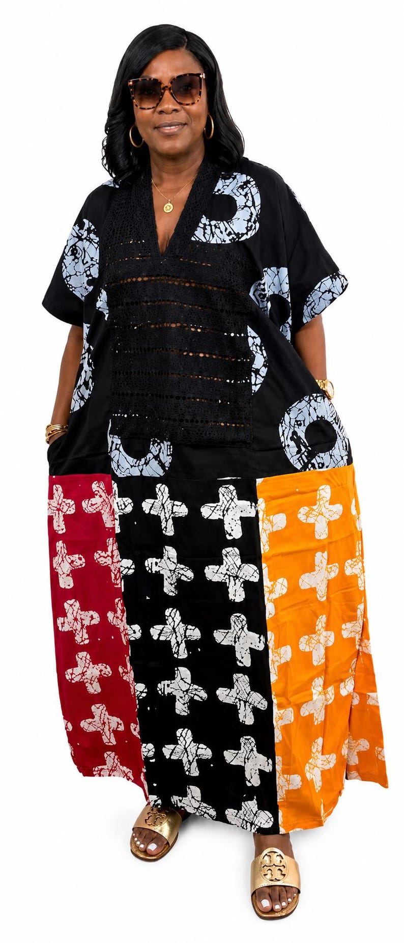 Pu&ograve; includere: Un abito caftano dalla vestibilit&agrave; ampia con una sezione superiore nera con motivi circolari bianchi e un pannello centrale in pizzo nero. La parte inferiore &egrave; a blocchi di colore rosso, nero e arancione, decorata con un motivo a croce bianca.