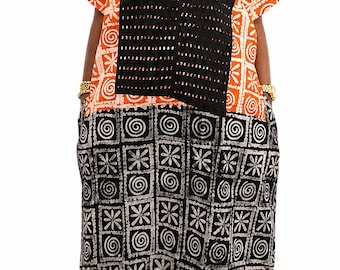 Könnte beinhalten: Ein bodenlanges Kleid mit einem orange-weiß gemusterten Oberteil und einem schwarz-weiß gemusterten Unterteil. Das Kleidungsstück verfügt über einen schwarzen, perforierten V-Ausschnitt und kurze Ärmel, die einen deutlichen Kontrast bilden.