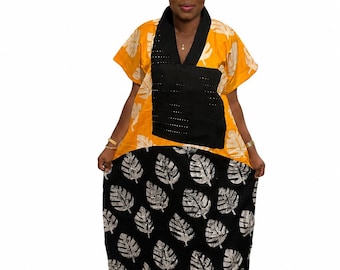 Könnte beinhalten: Ein zweifarbiges Kleid mit einem leuchtend gelben Oberteil mit weißem Blattmuster und einem schwarzen Unterteil mit weißem Blattdruck. Das Oberteil verfügt über einen schwarzen V-Ausschnitt und ein schwarzes Mittelteil mit kleinen silbernen Nieten.