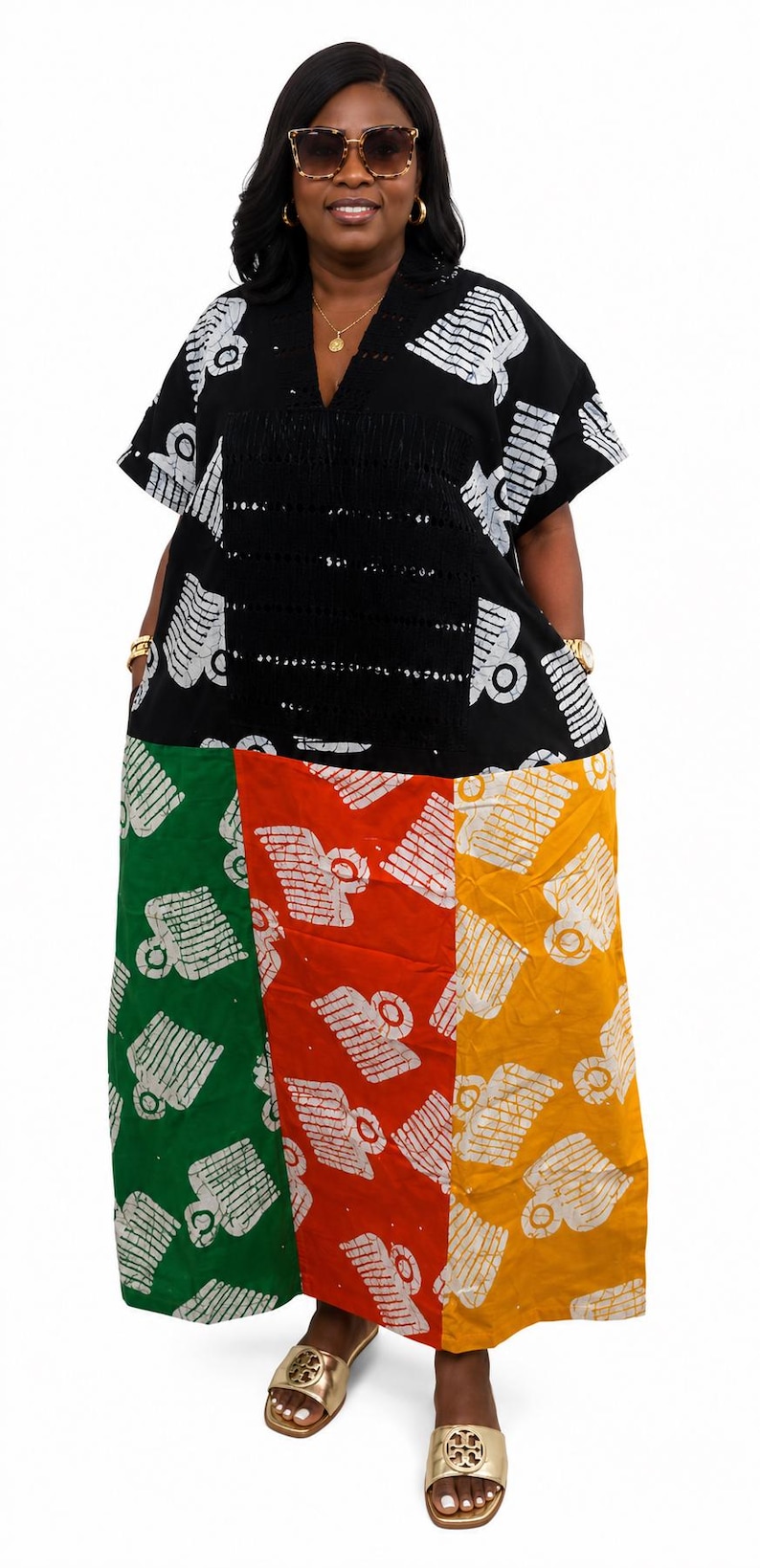 Pu&ograve; includere: Un abito caftano lungo fino ai piedi con corpetto nero, scollo a V e maniche corte, che prosegue con una gonna a blocchi di colore con pannelli verticali in verde, rosso e giallo, decorati con un motivo grafico bianco ripetuto.