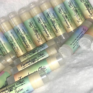 May include: A close-up of multiple tubes of lip balm with a white and green label that reads "Farmhouse Chic Chai Lip Balm".
