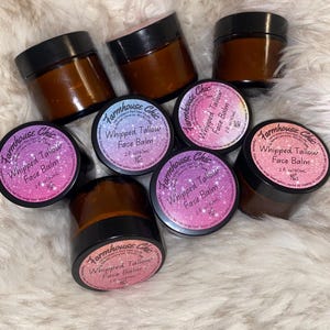 May include: Six amber glass jars with black lids containing a whipped tallow face balm. The jars are labelled "Farmhouse Chic Whipped Tallow Face Balm 2 fl oz/60ml".