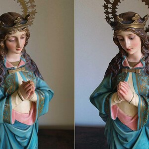 K&ouml;nnte beinhalten: Detaillierte Statue einer Frau mit Krone und Heiligenschein. Die Figur tr&auml;gt ein tealfarbenes Gewand mit goldenen Akzenten und ein rosa Unterhemd. Ihre H&auml;nde sind zum Gebet gefaltet. Die Statue hat einen ruhigen Ausdruck.