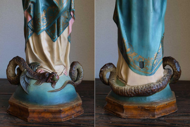 K&ouml;nnte beinhalten: Vintage Statuenfu&szlig; in T&uuml;rkis und Creme. Eine detaillierte Skulptur einer Schlange umkreist die F&uuml;&szlig;e der Figur. Die Kleidung der Statue hat goldene Akzente. Der Sockel ist aus Holz.