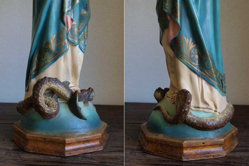 K&ouml;nnte beinhalten: Eine Vintage-Statue mit einer Figur in flie&szlig;enden Gew&auml;ndern, mit t&uuml;rkisfarbenen und goldenen Akzenten. Die Figur steht auf einem Sockel mit einer sich darum windenden Schlange. Der Sockel ist t&uuml;rkis und braun, mit detailliertem, gealtertem Aussehen.