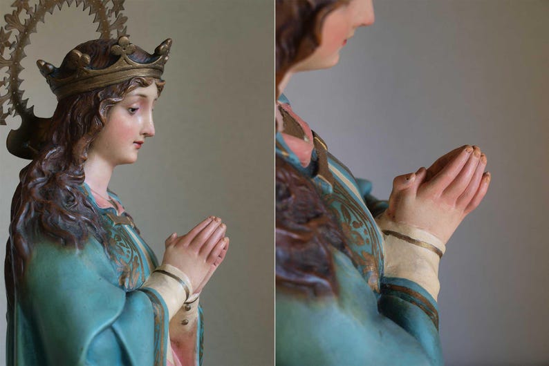 K&ouml;nnte beinhalten: Detaillierte Statue einer Frau mit Krone und Heiligenschein, die ein tealfarbenes Gewand mit goldenen Akzenten tr&auml;gt. Ihre H&auml;nde sind zum Gebet gefaltet. Die Statue hat einen ruhigen Ausdruck und ist mit realistischen Hautt&ouml;nen bemalt.