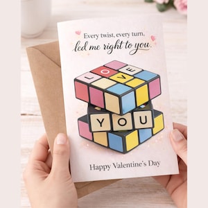 May include: Valentine's Day card featuring a colorful Rubik's Cube design with the word "LOVE" on top and "YOU" below. The card has the text "Every twist, every turn, led me right to you." and "Happy Valentine's Day".