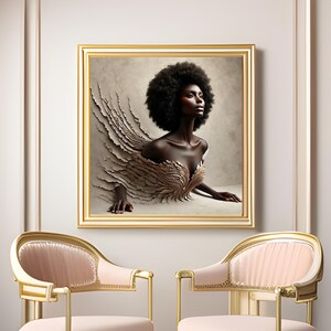 May include: A framed artwork depicting a woman with dark skin and a large afro hairstyle. The woman seems to be emerging from a textured background. The artwork is in a gold frame, and two pink chairs with gold frames are in the foreground.
