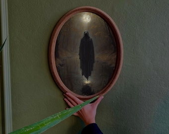 May include: Oval framed artwork depicting a cloaked figure in a dark landscape. The figure stands in water, illuminated by a light source. The frame is a light brown color, and the artwork is mounted on a green wall.