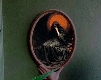 May include: A framed oval painting of a woman in a black dress sitting in a dark forest. The woman is looking down and her face is obscured by her hand. The background is a dark forest with a bright orange moon in the sky.