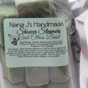 May include: A clear plastic bag filled with green shower steamers. The label reads "Nana J's Handmades Shower Steamers Cool Citrus Basil" and lists the ingredients and directions for use.