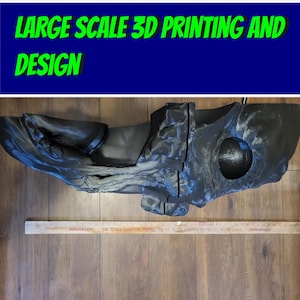 Puede incluir: Un objeto grande y negro impreso en 3D con un diseño orgánico complejo. El objeto tiene una superficie texturizada y una abertura circular. La imagen incluye el texto "LARGE SCALE 3D PRINTING AND DESIGN" en letras verdes sobre un fondo azul.