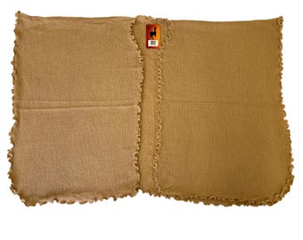 Può includere: Uno scialle di lana di alpaca marrone con un bordo arricciato. Lo scialle è fatto in Perù e presenta un piccolo tag con il logo di un lama.