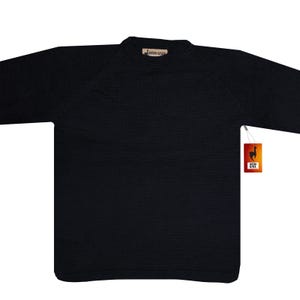 May include: A black crew neck sweater with raglan sleeves. The sweater has a tag that reads "Andean Alpaca" with a llama logo. The sweater is made of a soft, knitted material.