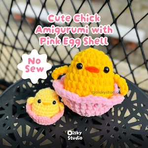May include: Two crocheted amigurumi chicks, one large and one small, each in a pink eggshell. The larger chick is yellow with black eyes and an orange beak. The text reads "Cute Chick Amigurumi with Pink Egg Shell" and "No Sew".