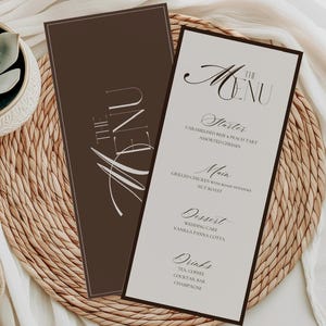Może przedstawiać: Dwie eleganckie karty menu z brązową obwódką i napisem "The Menu" kursywą. Menu zawiera przystawki, dania główne, deser i napoje. Tło to tkana podkładka i biała tkanina.
