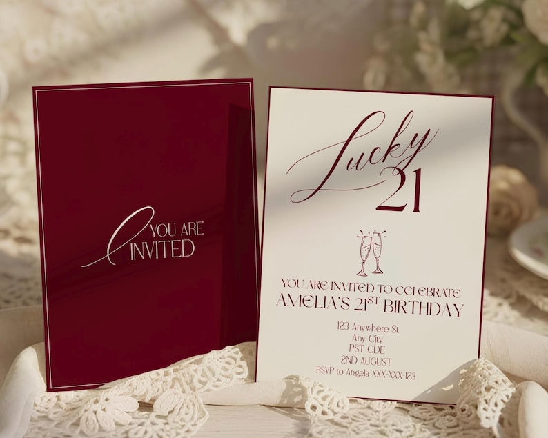 May include: Burgundy invitation card with the text "You are Invited" in white script. The open card displays "Lucky 21" in burgundy script, with details for Amelia's 21st birthday, including date, time, and RSVP information.