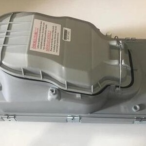 a gray plastic container with a warning label on it.