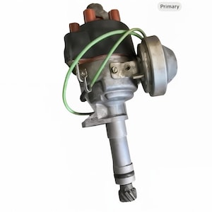 May include: A silver automotive distributor with a black cap, red terminals, and green wiring. The distributor has a cylindrical body and a gear at the bottom. It is a mechanical component for an internal combustion engine.