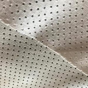 a close-up view of a fabric with a perforated pattern, featuring numerous small holes or dots.