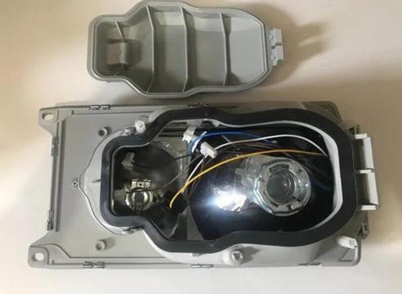 the interior of a vehicle, specifically the front headlight assembly, with the headlight removed and the headlight housing visible.