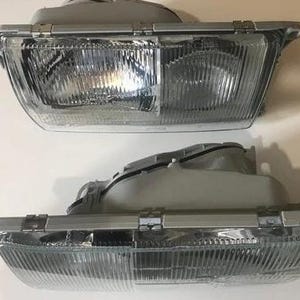 two front headlight units, both of which appear to be made of metal and have a clear, reflective surface.