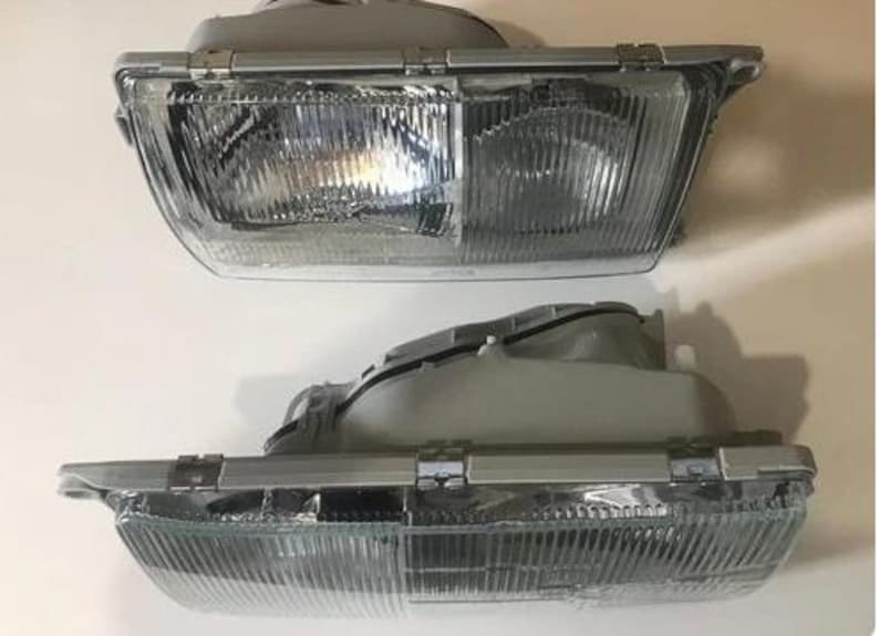 two front headlight units, both of which appear to be made of metal and have a clear, reflective surface.