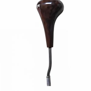May include: A car gear shift knob with a glossy, dark brown wooden top and a chrome-colored metal shaft. The knob has a teardrop shape and a smooth, polished finish. The shaft is curved.