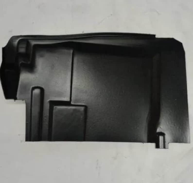 A black plastic car part, likely a trunk lid or cover, is shown against a white background.