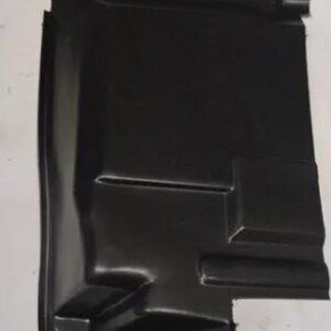 a black plastic object, possibly a car part or a protective cover, against a white background.