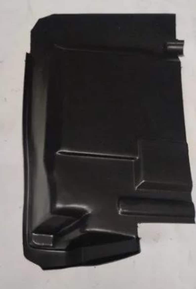 a black plastic object, possibly a car part or a protective cover, against a white background.