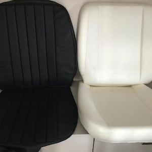 two car seat cushions, one black and one white, placed side by side.