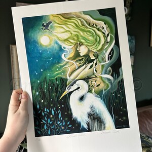 May include: A limited edition art print of a woman with flowing green hair and a white egret. The print is signed by the artist,  'Amanda Clarke', and numbered '5/100'.
