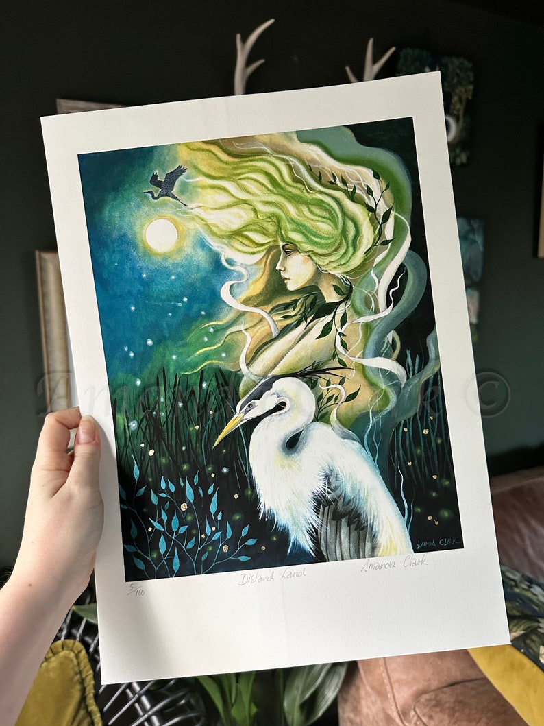 May include: A limited edition art print of a woman with flowing green hair and a white egret. The print is signed by the artist,  'Amanda Clarke', and numbered '5/100'.