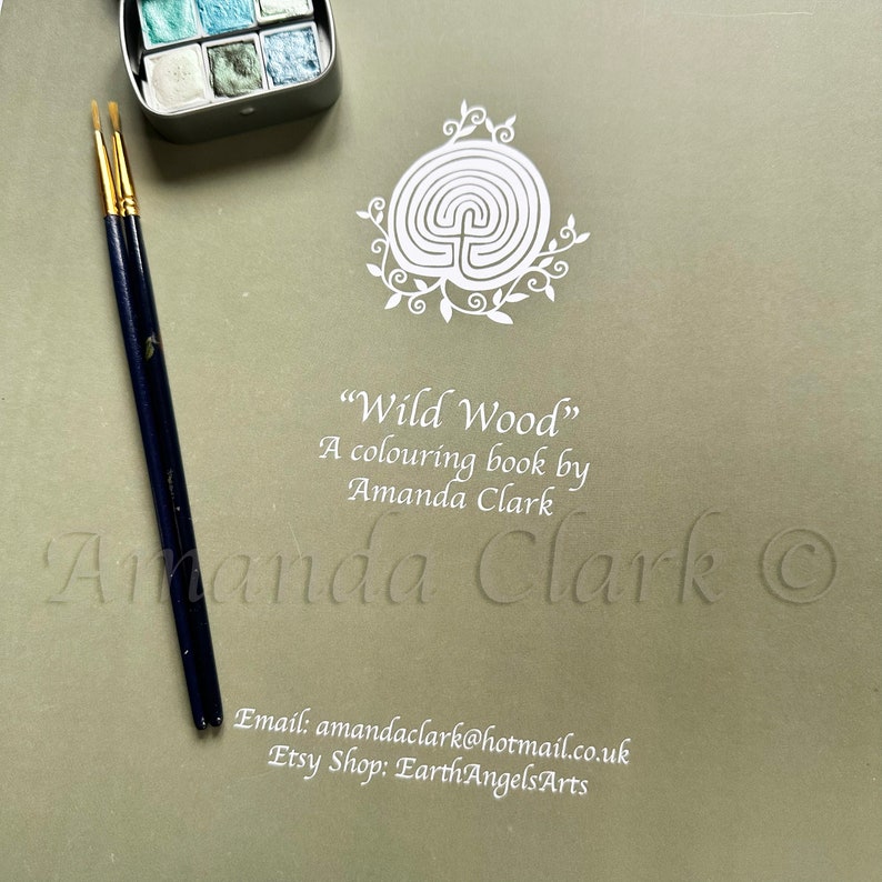 Puede incluir: Una ilustraci&oacute;n blanca de un laberinto rodeado de hojas sobre un fondo verde. El texto "Wild Wood" est&aacute; escrito debajo de la ilustraci&oacute;n, seguido de "A colouring book by Amanda Clark". Tambi&eacute;n se incluye el nombre del artista y el s&iacute;mbolo de copyright.