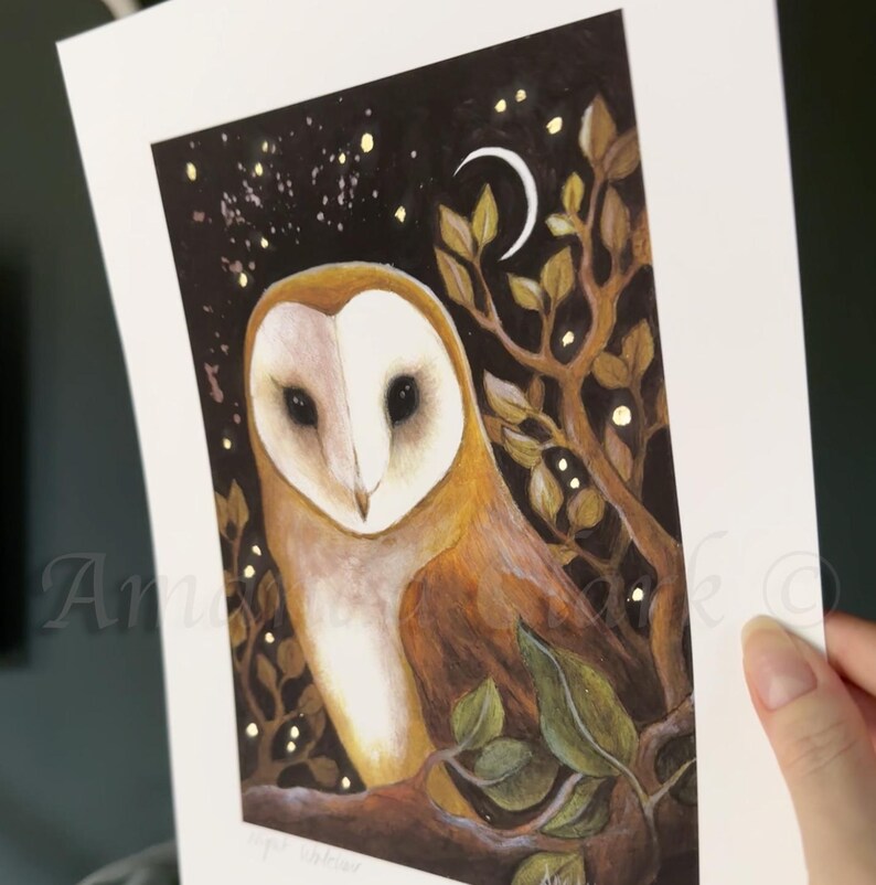 Puede incluir: Un b&uacute;ho blanco y marr&oacute;n con grandes ojos oscuros est&aacute; posado en una rama en un bosque oscuro. El b&uacute;ho est&aacute; rodeado de hojas doradas brillantes y una luna creciente. El fondo es azul oscuro con estrellas doradas.