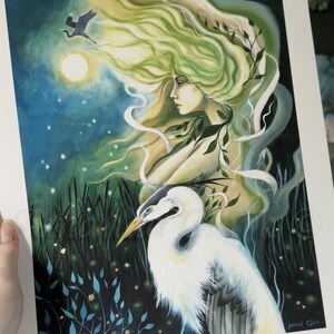 May include: A watercolor painting of a woman with flowing green hair and a white egret. The woman is surrounded by a blue and green background with a full moon and stars. The painting is signed "Miranda Clarke" in the bottom right corner.