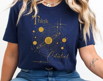 Puede incluir: Una camiseta azul marino con un gráfico dorado de un sistema solar y el texto "Think Celestial".