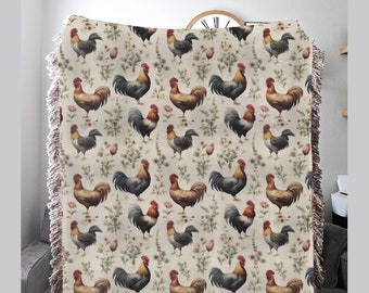 May include: A woven throw blanket with a cream background and a repeating pattern of colorful roosters and floral accents.