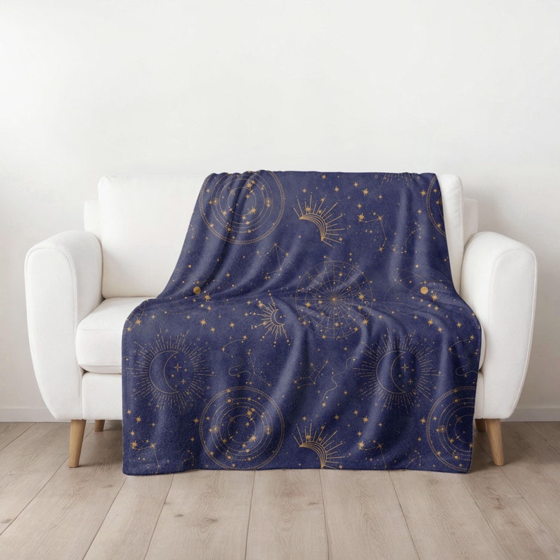 May include: A navy blue throw blanket with a gold celestial pattern featuring stars, moons, and constellations.