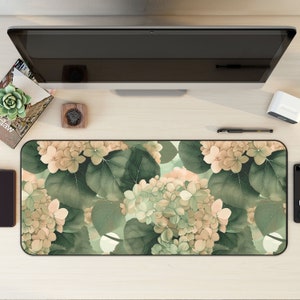 May include: A floral mouse mat with a design of light brown and green hydrangeas on a green background.