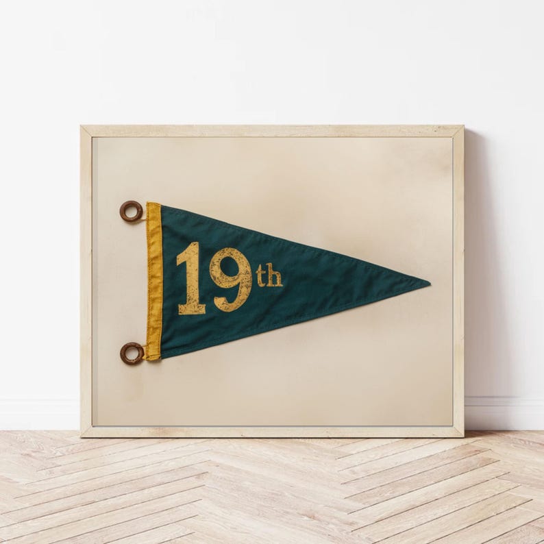 May include: A framed print of a vintage pennant with a dark green background and gold lettering. The pennant reads "19th".