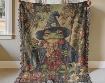 May include: A green frog wearing a blue and red wizard hat and robe, holding a staff. The frog is surrounded by flowers and greenery. The background is a tapestry with a floral pattern.