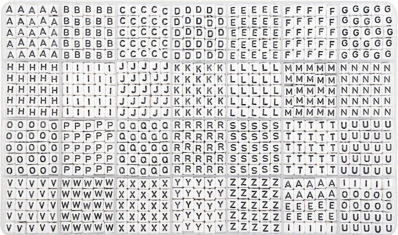 May include: A white plastic organizer filled with small, square letter tiles. The tiles have black uppercase letters and numbers. The letters are arranged alphabetically in rows and columns, ideal for crafting.