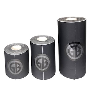 K&ouml;nnte beinhalten: Drei Rollen schwarzes Griptape mit einer wei&szlig;en Mitte und einem schwarzen Kreis mit den Buchstaben GB in wei&szlig;. Die Rollen sind unterschiedlich gro&szlig;.