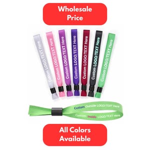 Op de afbeelding: Een verzameling gekleurde polsbandjes met de tekst "Custom LOGO/TEXT Here" erop. De polsbandjes zijn in verschillende kleuren, waaronder grijs, roze, paars, bordeaux, zwart en groen. De afbeelding bevat ook de tekst "Wholesale Price" en "All Colors Available".