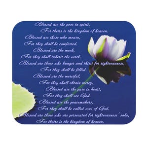 Puede incluir: Posavasos cuadrado con fondo azul y escritura blanca. Un lirio de agua blanco y morado está en la esquina superior derecha. El texto incluye un pasaje de la Biblia, con las palabras "Bienaventurados los pobres en espíritu..."