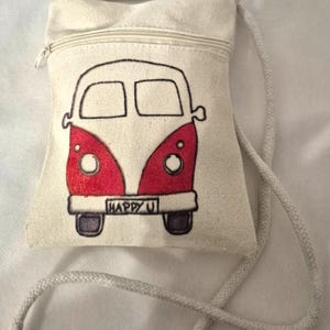 Peut inclure: Petit sac bandoulière en toile écrue avec fermeture éclair et cordon tressé. Il présente une illustration rouge et blanche d'un van vintage avec le texte "HAPPY U" en bas.